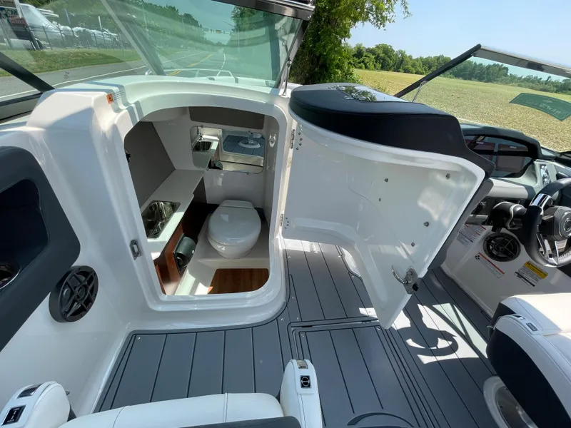 Slide: The Image of 2024 Chaparral 250 OSX boat interior with open cabin door and visible toilet. - 33