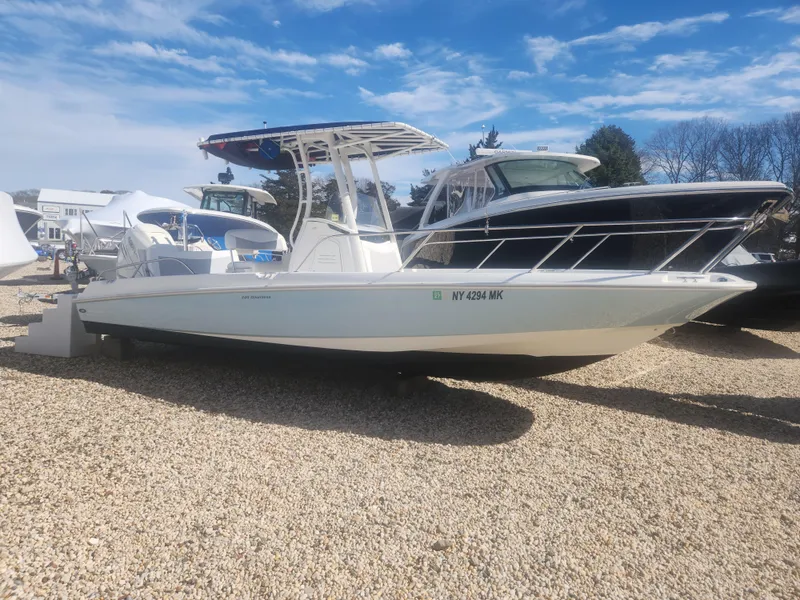 Slide: The Image of 2015 Boston Whaler 240 Dauntless boat on gravel lot under blue sky. - 0