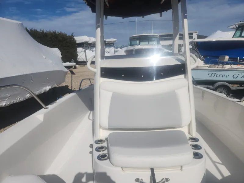 Slide: The Image of 2015 Boston Whaler 240 Dauntless boat interior with seating and console, docked outdoors. - 11