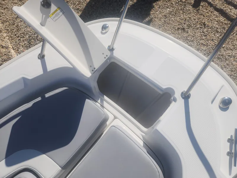 Slide: The Image of 2015 Boston Whaler 240 Dauntless boat storage compartment with open lid and seating area. - 14