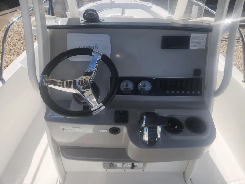 Slide: The Image of 2015 Boston Whaler 240 Dauntless boat dashboard with steering wheel and controls. - 7