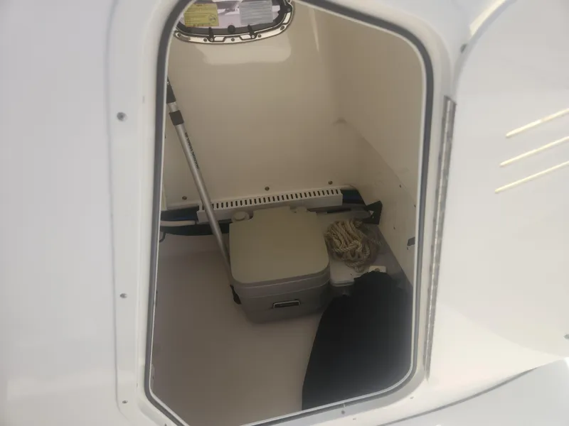 Slide: The Image of 2015 Boston Whaler 240 Dauntless storage compartment with portable toilet and equipment. - 8