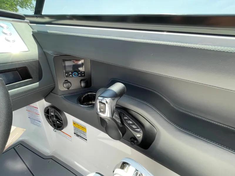 Slide: The Image of 2024 Chaparral 250 OSX boat dashboard with controls and cup holder. - 20