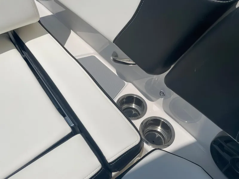 Slide: The Image of 2024 Chaparral 250 OSX boat interior with white seating and stainless steel cup holders. - 37