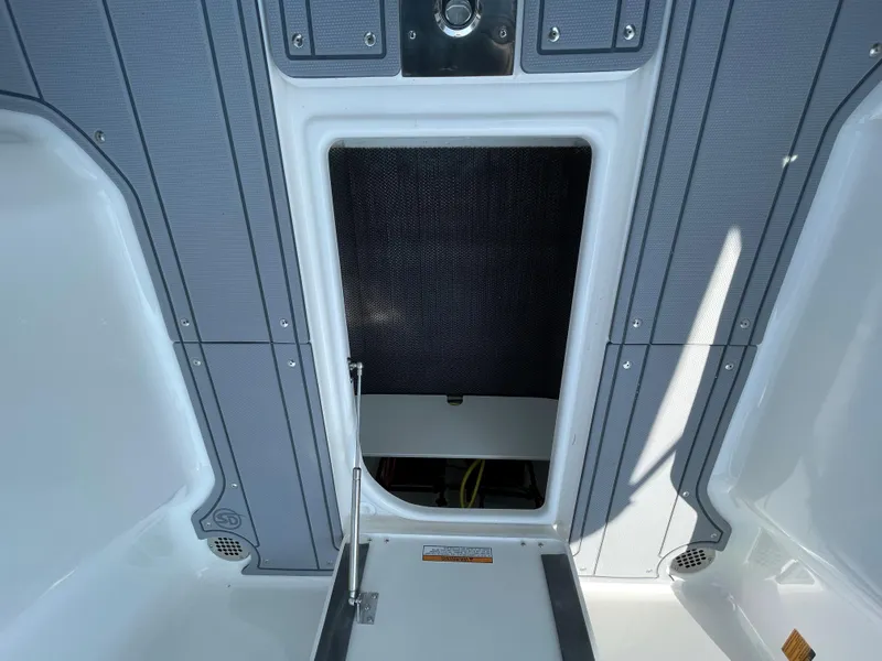 Slide: The Image of 2024 Chaparral 250 OSX boat interior storage compartment with open hatch. - 44