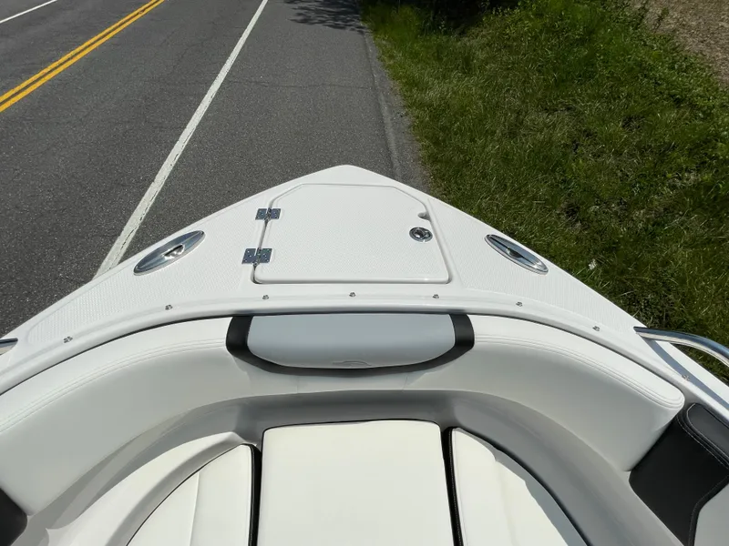 Slide: The Image of 2024 Chaparral 250 OSX boat bow with white seating and storage compartment. - 5
