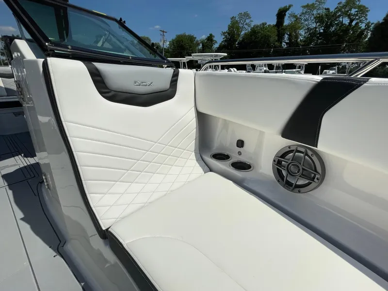 Slide: The Image of 2024 Chaparral 250 OSX boat interior with white seating and speaker system. - 11