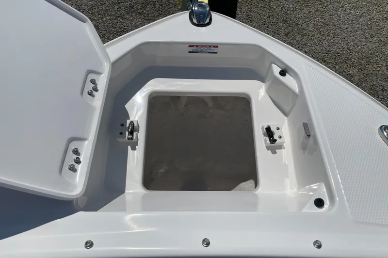 Slide: The Image of 2024 Chaparral 250 OSX boat storage compartment with open hatch, showcasing interior space. - 5