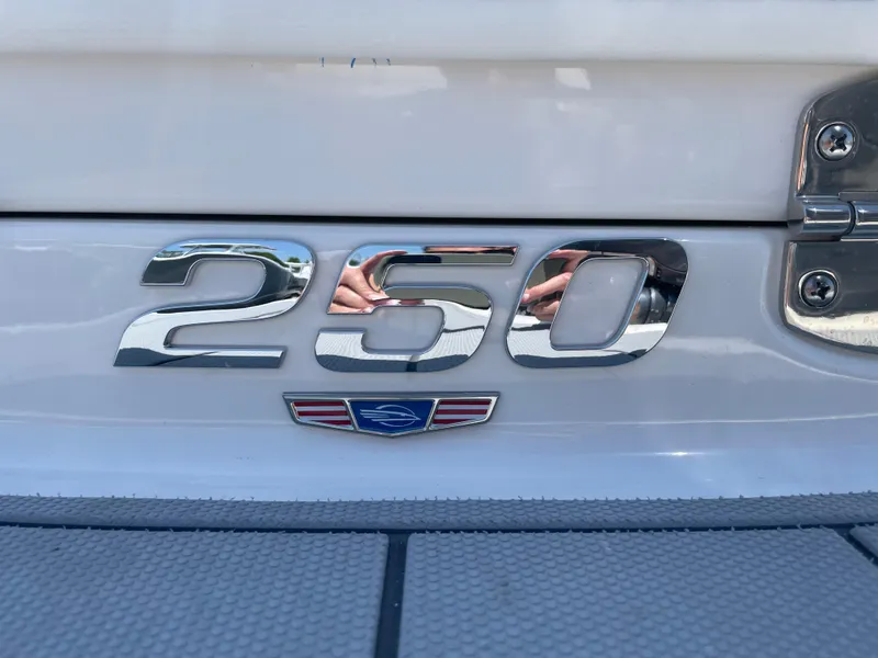 Slide: The Image of 2024 Chaparral 250 OSX boat emblem with chrome finish and logo detail. - 2