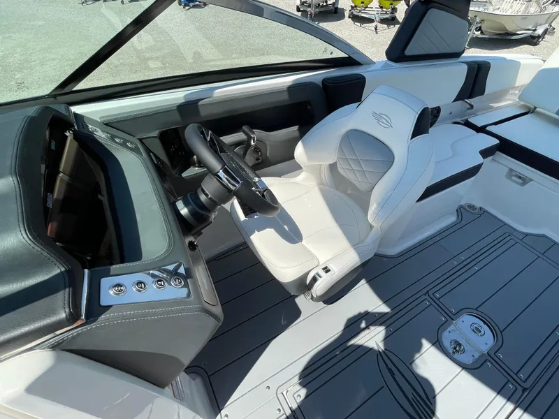 Slide: The Image of 2024 Chaparral 250 OSX boat cockpit with modern steering and luxurious seating. - 28