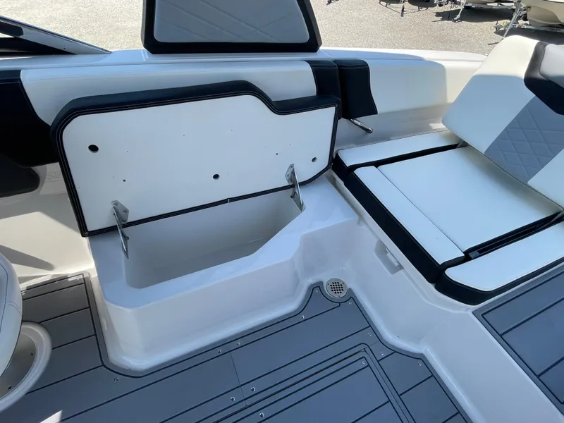 Slide: The Image of 2024 Chaparral 250 OSX boat interior with open storage compartment and seating. - 41