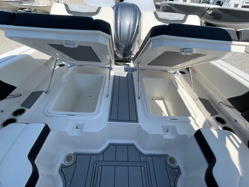 Slide: The Image of 2024 Chaparral 250 OSX boat with open storage compartments and sleek seating design. - 46