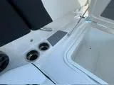 Slide: The Image of 2024 Chaparral 250 OSX boat interior with open storage compartment and cup holders. - 48