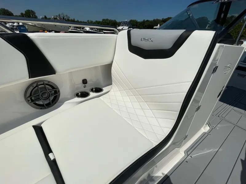 Slide: The Image of 2024 Chaparral 250 OSX boat interior with white seating and speaker. - 9