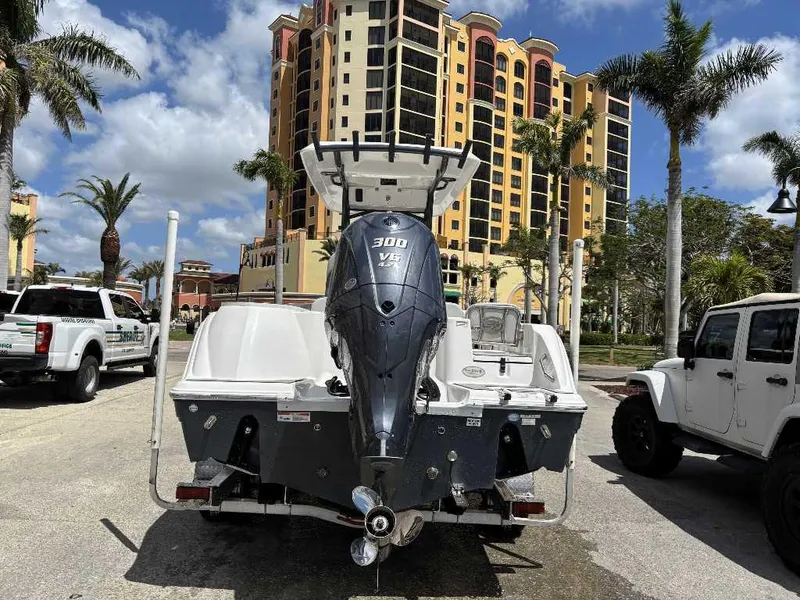 Slide: The Image of 2022 Sea Fox 248 Commander boat with powerful engine, parked near palm trees and buildings. - 9