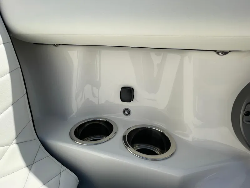 Slide: The Image of 2024 Chaparral 250 OSX boat interior with dual cup holders and quilted seating. - 14