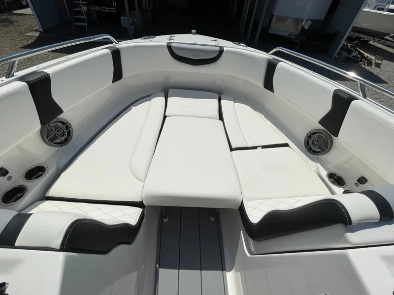 Slide: The Image of 2024 Chaparral 250 OSX boat interior with white cushioned seating and cup holders. - 18
