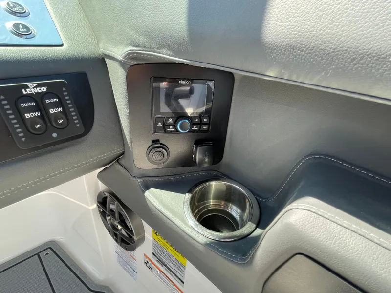 Slide: The Image of 2024 Chaparral 250 OSX boat dashboard with control panel, cup holder, and audio system. - 25