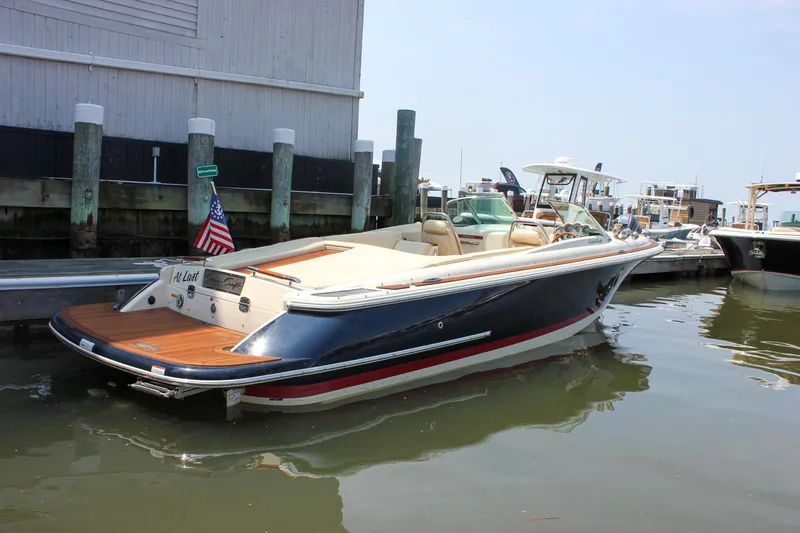 Slide: The Image of 2016 Chris-Craft Launch 25 boat docked at marina, featuring elegant design and American flag. - 0