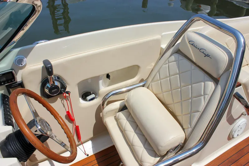 Slide: The Image of 2016 Chris-Craft Launch 25 boat interior with leather seat and wooden steering wheel. - 16