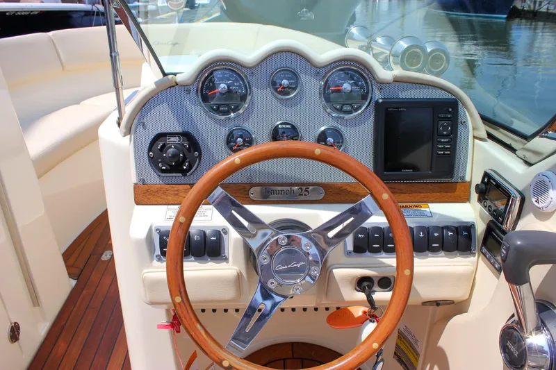 Slide: The Image of 2016 Chris-Craft Launch 25 dashboard with wooden steering wheel and instrument panel. - 18