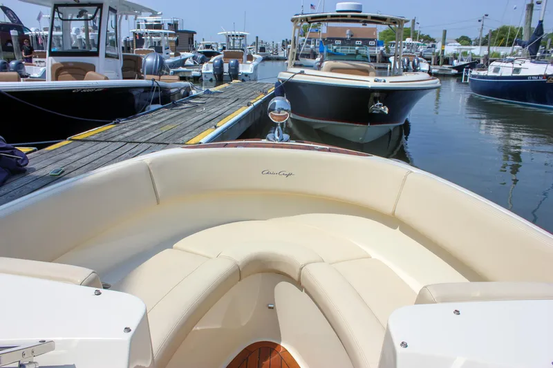 Slide: The Image of 2016 Chris-Craft Launch 25 boat docked at marina, featuring elegant seating and classic design. - 20