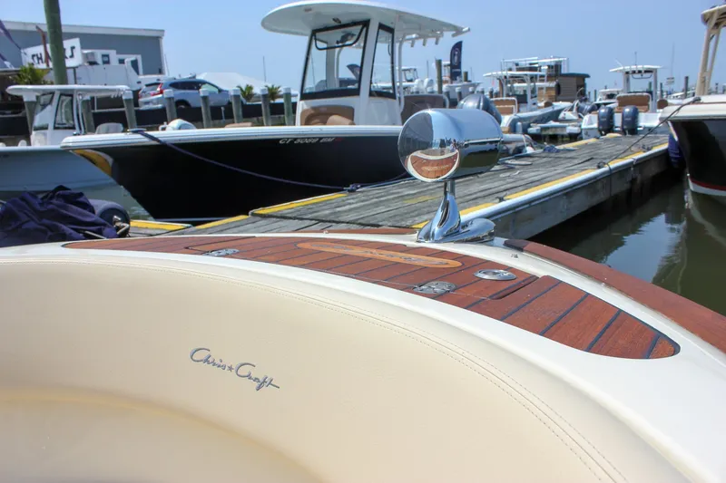 Slide: The Image of 2016 Chris-Craft Launch 25 boat docked, showcasing elegant design and polished wood accents. - 22