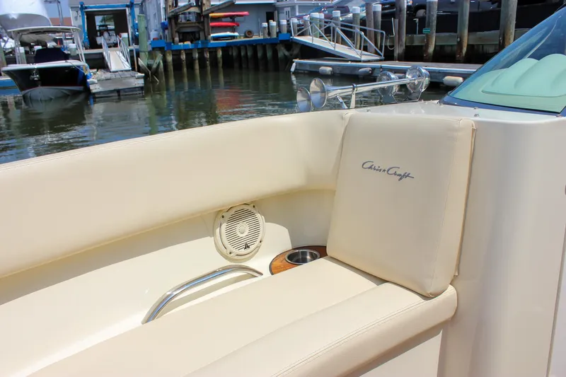 Slide: The Image of 2016 Chris-Craft Launch 25 boat interior with beige seating and speaker, docked at marina. - 24