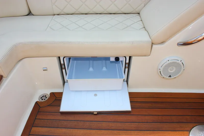 Slide: The Image of 2016 Chris-Craft Launch 25 interior with cushioned seating and built-in storage drawer. - 28