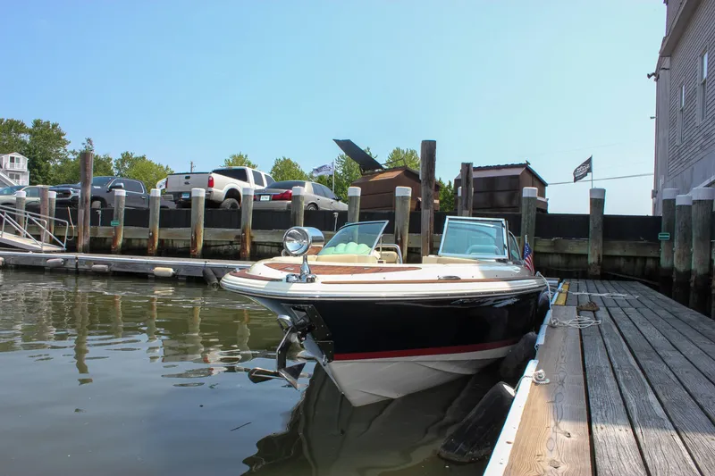 Slide: The Image of 2016 Chris-Craft Launch 25 boat docked in a marina, sunny day, calm water. - 3