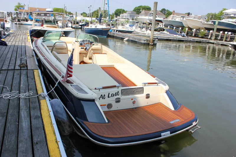 Slide: The Image of 2016 Chris-Craft Launch 25 boat docked in a marina, featuring elegant wood detailing. - 32