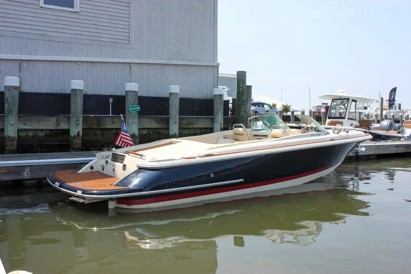 Slide: The Image of 2016 Chris-Craft Launch 25 boat docked at marina, featuring sleek design and American flag. - 35