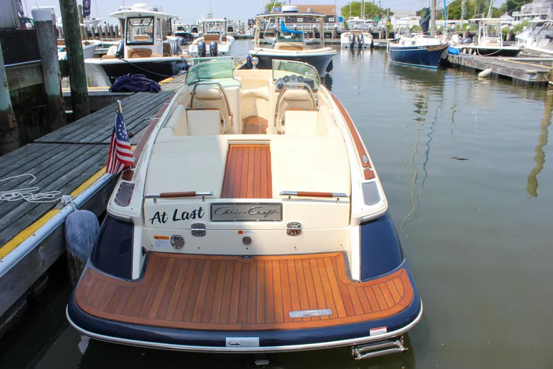 Slide: The Image of 2016 Chris-Craft Launch 25 boat docked in a marina, featuring elegant wood detailing. - 36