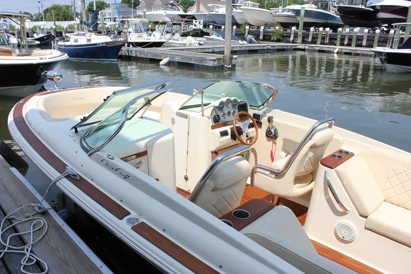 Slide: The Image of 2016 Chris-Craft Launch 25 boat docked in a marina, showcasing elegant interior and dashboard. - 38