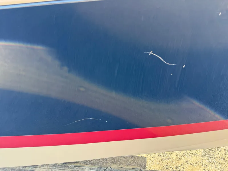 Slide: The Image of 2016 Chris-Craft Launch 25 boat hull with visible scratches and red stripe. - 46