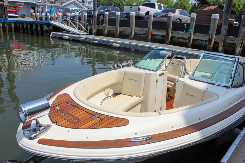 Slide: The Image of 2016 Chris-Craft Launch 25 boat docked, featuring elegant wood accents and cream seating. - 6