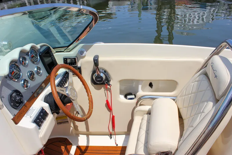 Slide: The Image of 2016 Chris-Craft Launch 25 boat interior with steering wheel and dashboard controls. - 9