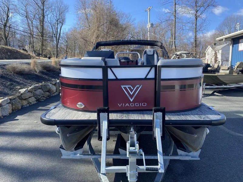 Slide: The Image of 2023 Viaggio Lago U L20U pontoon boat, red and white, parked on a trailer. - 6