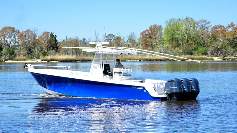 Slide: The Image of 2015 Contender 35 ST boat with triple Yamaha engines on a calm lake. - 2