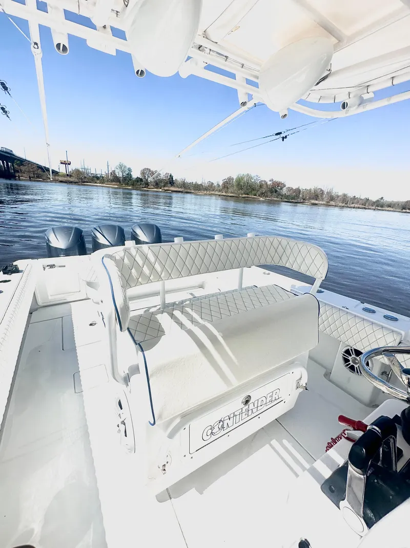 Slide: The Image of 2015 Contender 35 ST boat interior with seating, steering wheel, and triple outboard motors. - 6