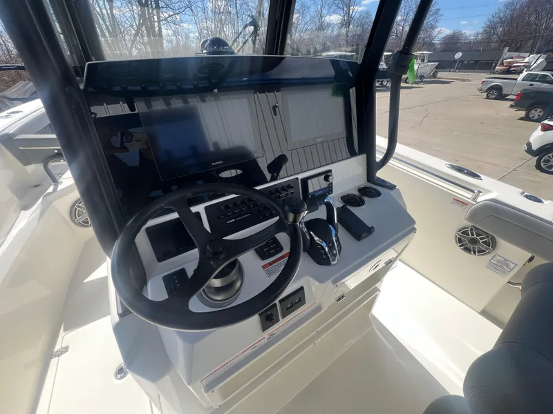 Slide: The Image of 2025 Cobia 285 Open Center Console boat dashboard with steering wheel and controls. - 10