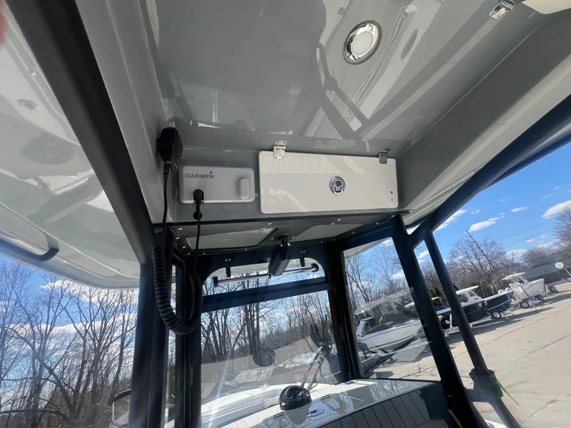 Slide: The Image of 2025 Cobia 285 Open Center Console boat interior with Garmin electronics and storage compartment. - 11