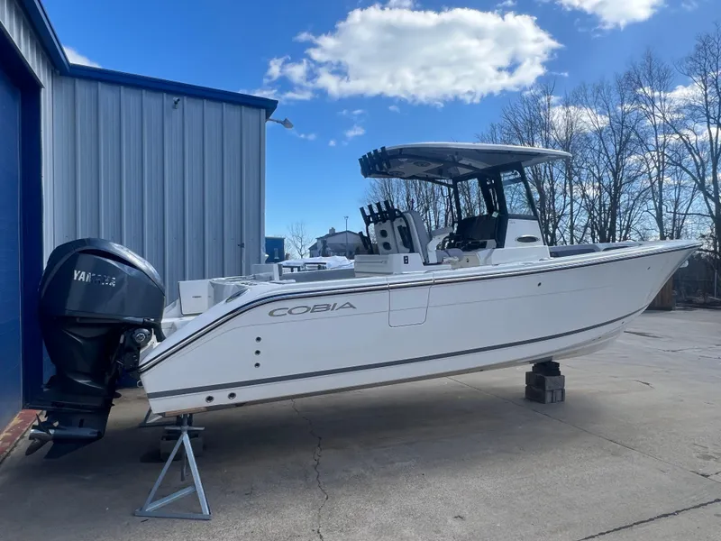 Slide: The Image of 2025 Cobia 285 Open Center Console boat with Yamaha engine, parked outdoors. - 3