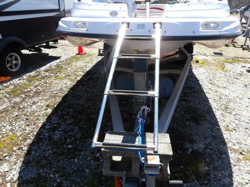 Slide: The Image of 2008 Starcraft Stardeck 200 boat on trailer with ladder, parked on gravel. - 7