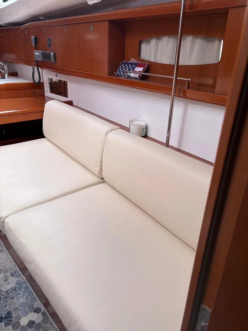 Slide: The Image of Interior of 2011 Beneteau Oceanis 40 yacht with beige seating and wooden cabinetry. - 17