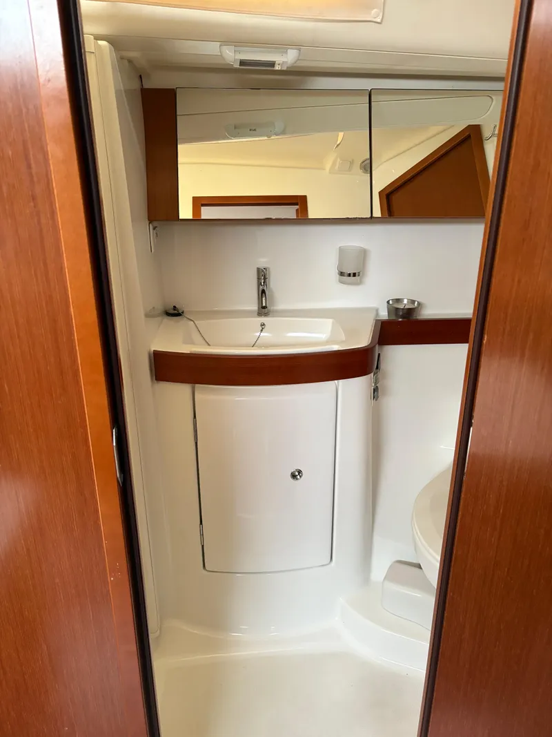 Slide: The Image of 2011 Beneteau Oceanis 40 bathroom with sink, mirror, and wooden accents. - 18