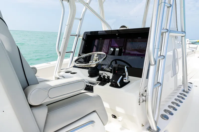 Slide: The Image of 2015 SeaVee 390Z boat console with steering wheel and controls, set against a turquoise sea backdrop. - 24