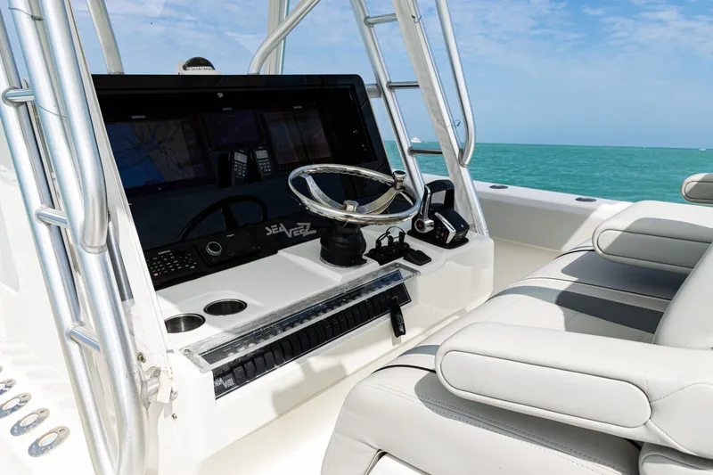 Slide: The Image of 2015 SeaVee 390Z boat console with steering wheel, controls, and seating, against ocean backdrop. - 25