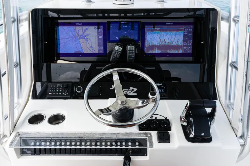 Slide: The Image of Control panel of a 2015 SeaVee 390Z boat with navigation screens and steering wheel. - 26