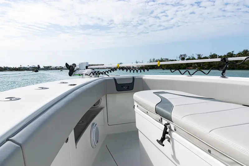Slide: The Image of 2015 SeaVee 390Z boat interior with cushioned seating and rod holders on a sunny day. - 31